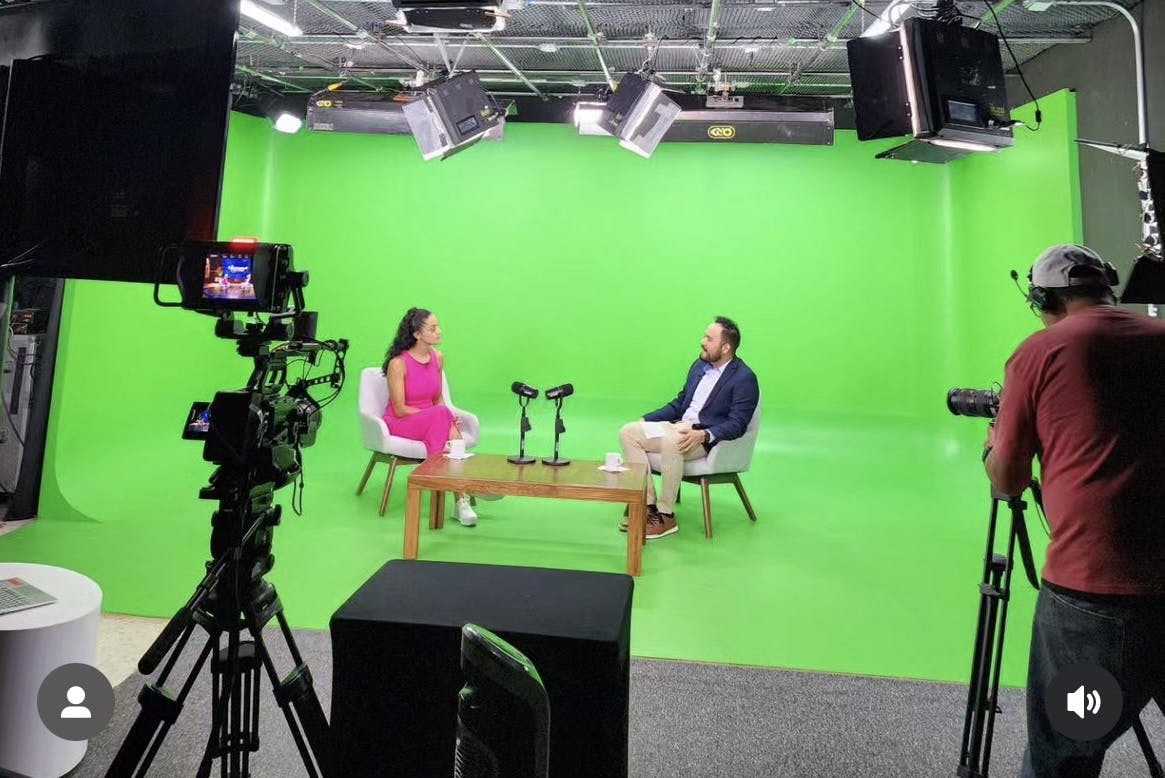 Ponentes en conversación en escenario virtual de foro sinergis green screen