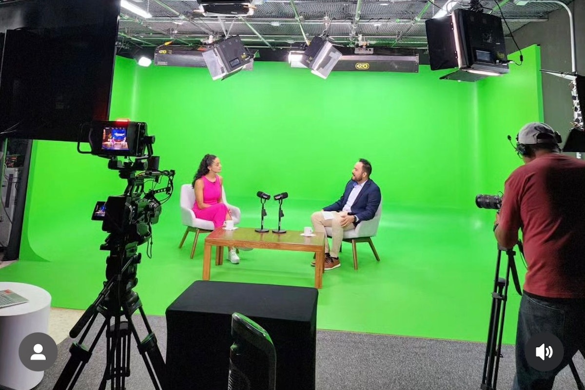 Ponentes en conversación en escenario virtual de foro sinergis green screen